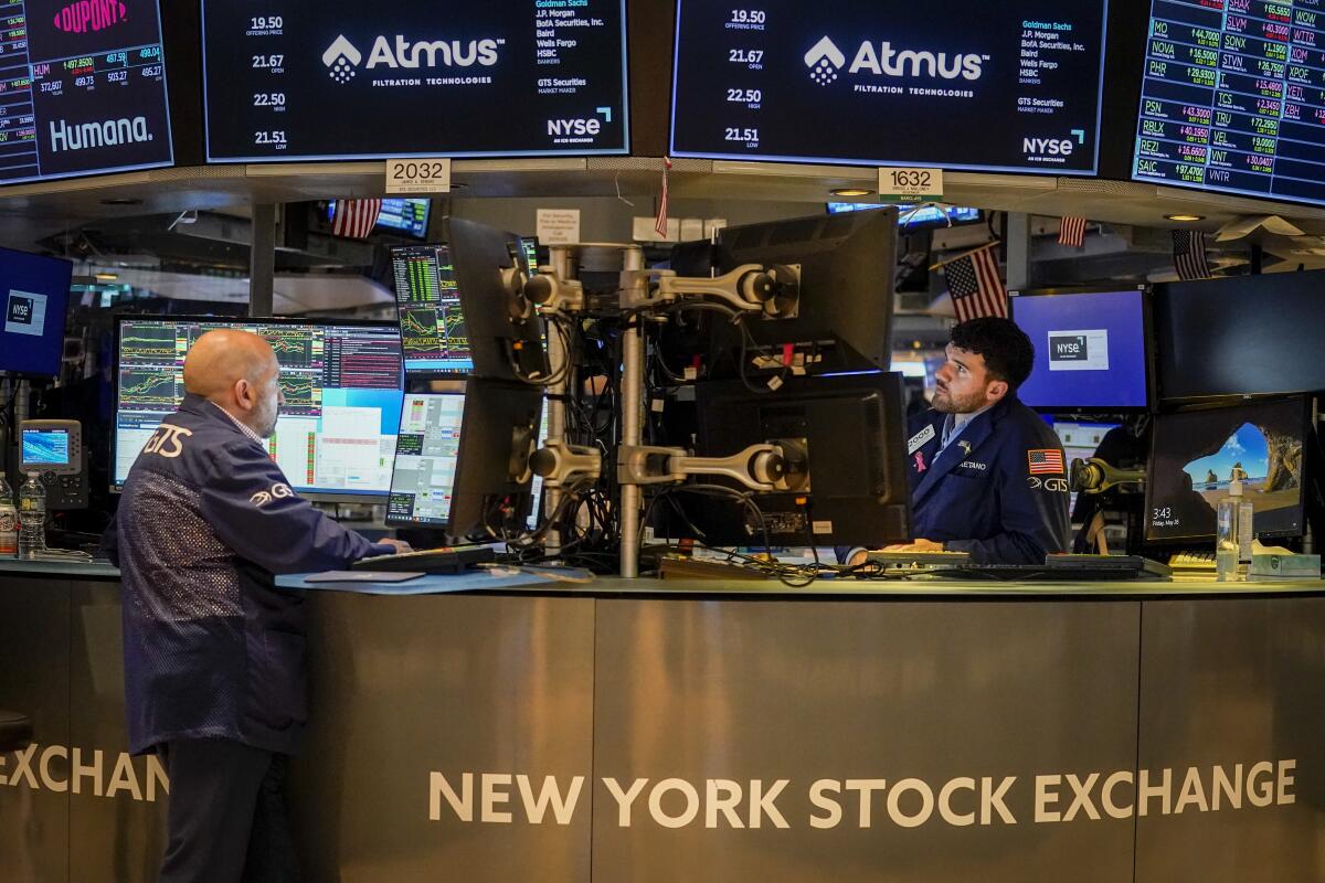 Two traders work at their stations at the New York Stock Exchange
