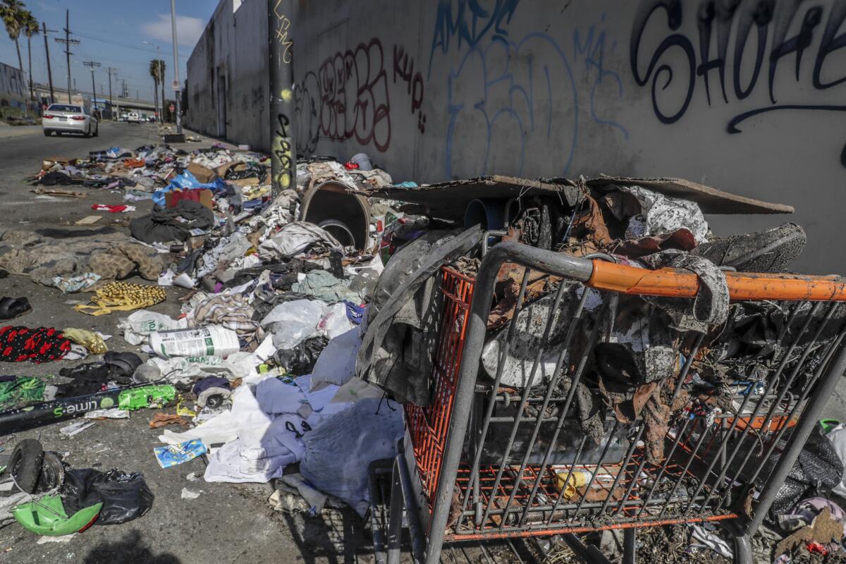 A shopping cart and piles of trash at the corner of Compton Avenue and East 16th Street.