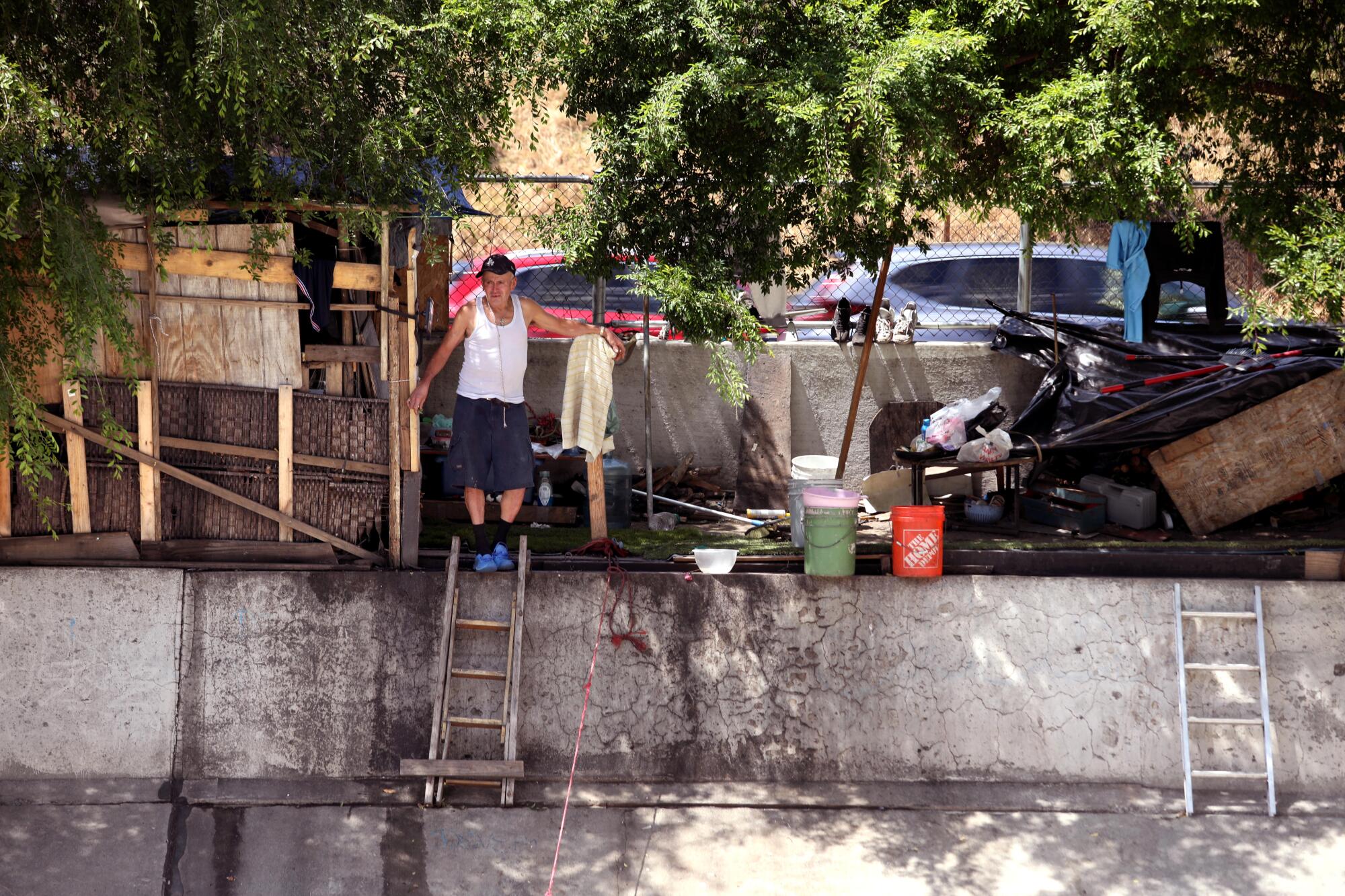 A man looks out from his makeshift home as traffic speeds by on the 110 Freeway in Highland Park.