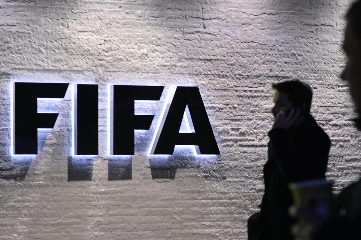 A man stands in front of the logo at the FIFA headquarters in Zurich, Switzerland on Dec. 2. (Walter Bieri/Keystone via AP)