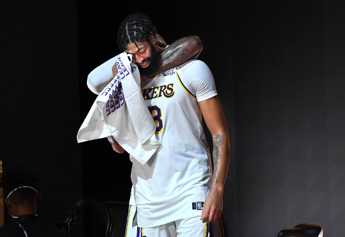 Anthony Davis is hugged from behind by LeBron James after winning the NBA title on Oct. 10, 2020, in Orlando, Fla.