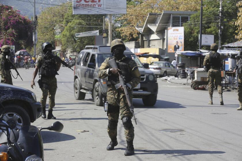 Members of the General Security Unit of the National Palace, USGPN, set up a security perimeter around one of the three downtown stations after police fought off an attack by gangs the day before, in Port-au-Prince, Haiti, Saturday, March 9, 2024. (AP Photo/Odelyn Joseph)