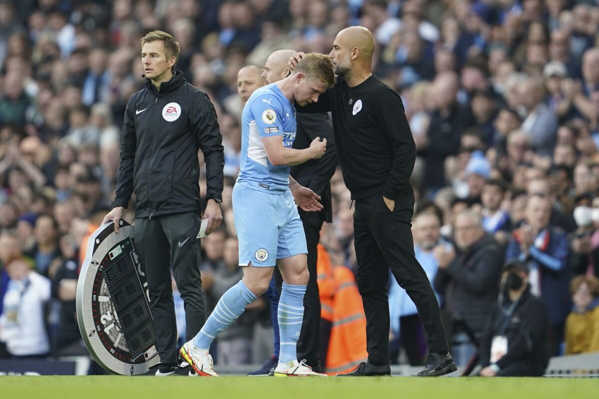 Manchester City's Kevin De Bruyne, left, is congratulated by Manchester City's head coach Pep Guardiola as he is substituted during the English Premier League soccer match between Manchester City and Burnley at Etihad stadium in Manchester, England, Saturday, Oct. 16, 2021. (AP Photo/Jon Super)