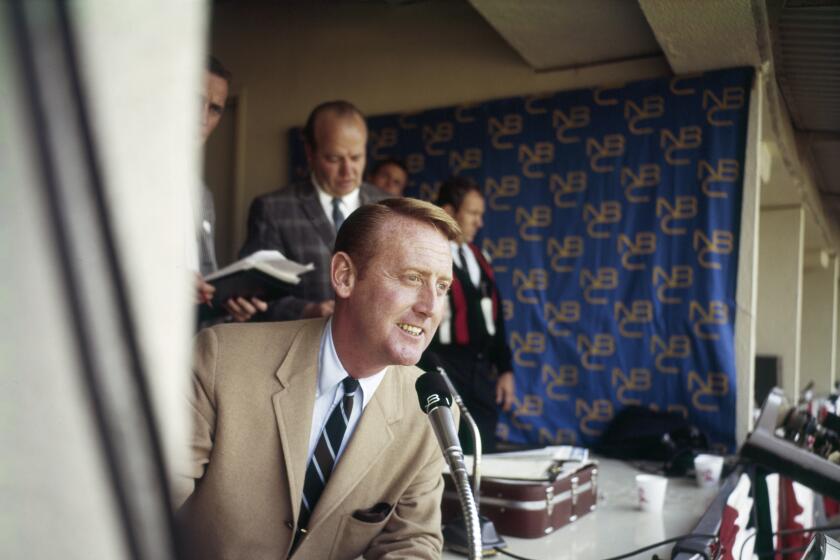 Voice of the Dodgers Vin Scully leans out of the press box during the 1960s 