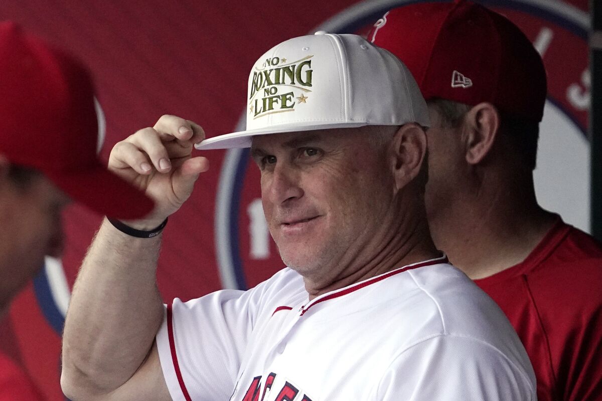 Angels interim manager Phil Nevin tries on a cap before a game against the Boston Red Sox on June 9, 2022.