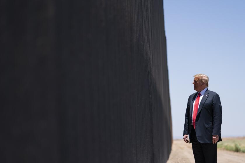 FILE - In this June 23, 2020, file photo, President Donald Trump tours a section of the border wall in San Luis, Ariz. While Mexico never did pay for the “big, beautiful wall” Trump pledged to build along the southern border — the signature promise of his 2016 campaign — the project is now under way, with 450 miles expected to be completed by the end of December (only a fraction of that, however, has been built along stretches where no barrier stood before.) (AP Photo/Evan Vucci, File)