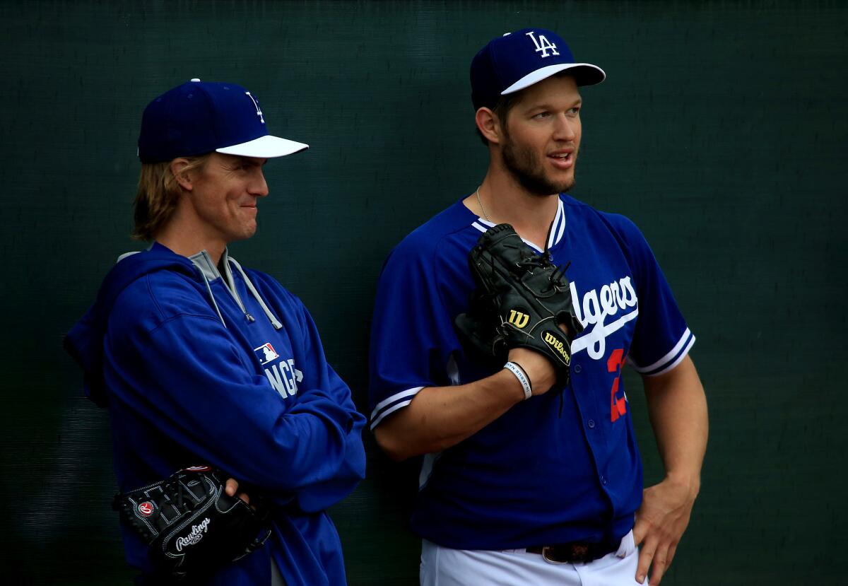 Zack Greinke, left, and Clayton Kershaw talk during spring training on March 2, 2015, in Glendale, Ariz. The two will face each other for the first time on Friday.