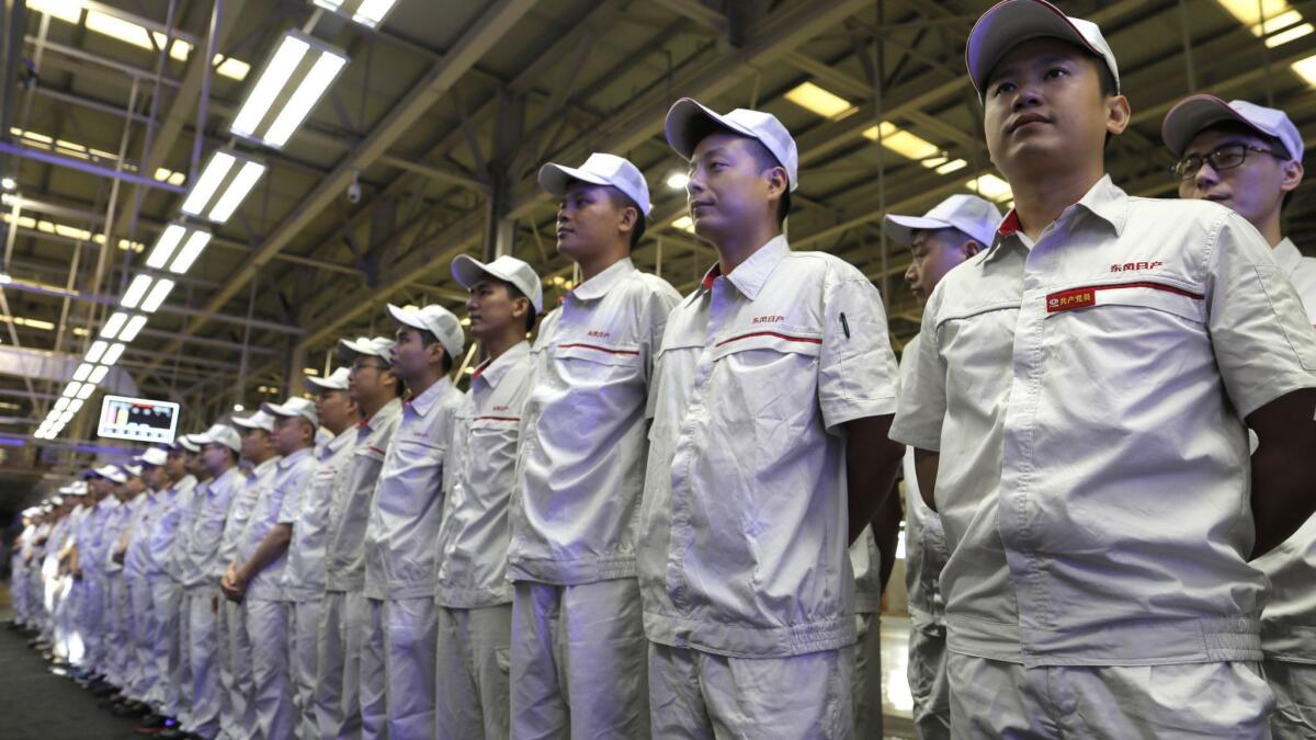 Nissan workers in China attend the ceremony launching the Nissan Sylphy Zero Emission.