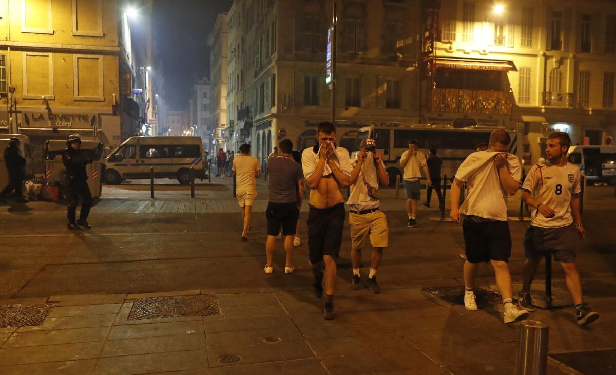 Aficionados de Inglaterra se cubren la cara después de que la policía arrojase gas lacrimógeno tras un partido del Grupo B de la Eurocopa de Francia entre Inglaterra y Rusia en Marsella, Francia, el 11 de junio de 2016. (AP Foto/Darko Bandic) ** Usable by HOY, ELSENT and SD Only **
