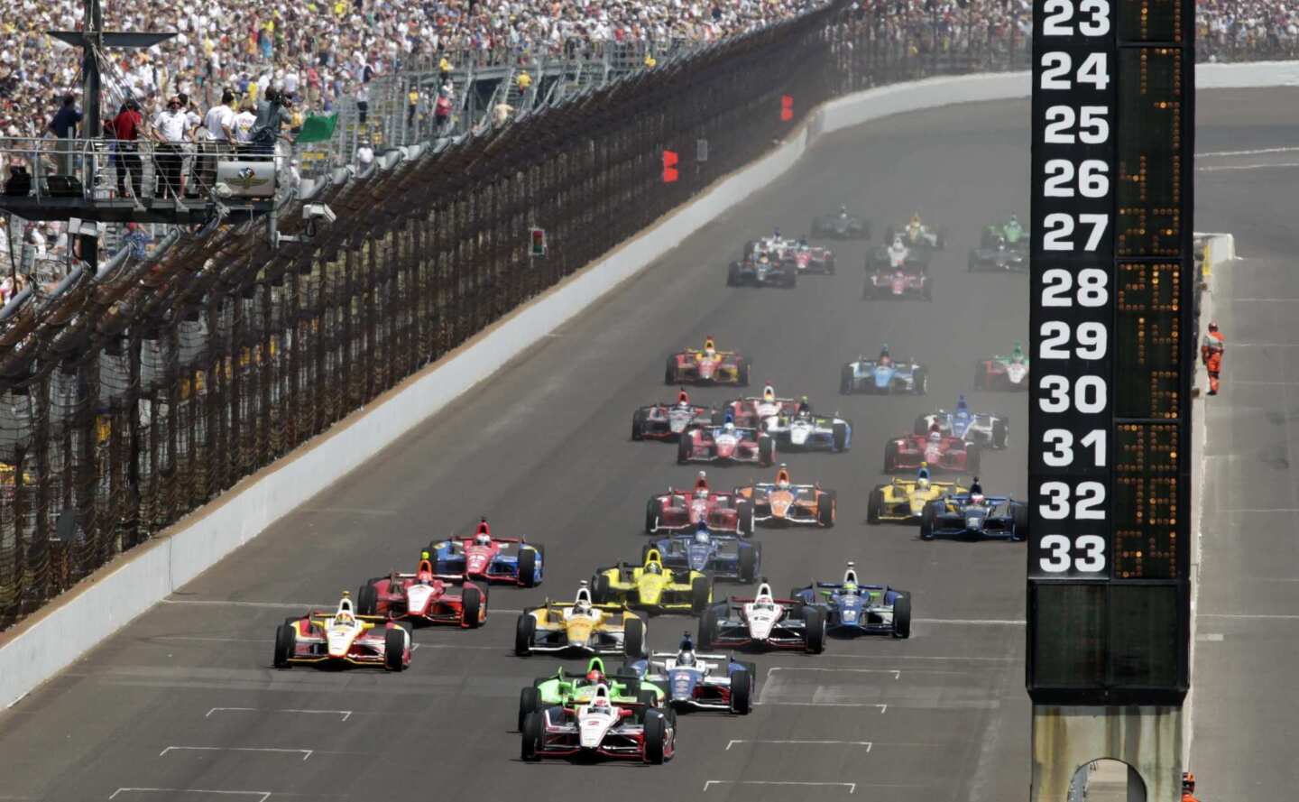 Pole-sitter Ryan Briscoe leads the field across the start/finish line to begin the 96th running of the Indianapolis 500 on Sunday.