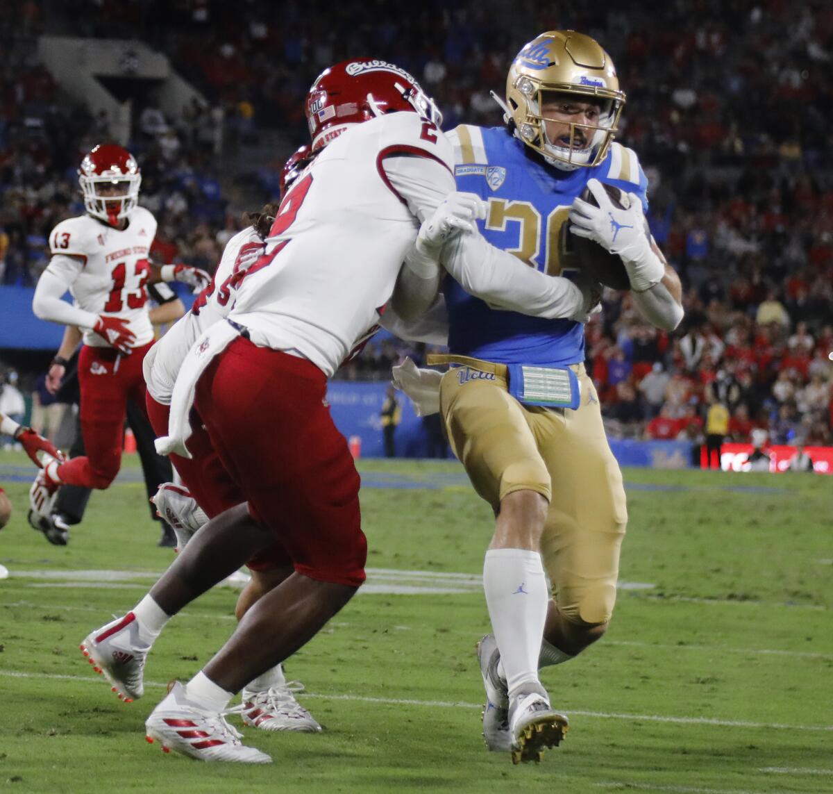 Fresno State defensive back Elijah Gates forces UCLA running back Ethan Fernea out of bounds.