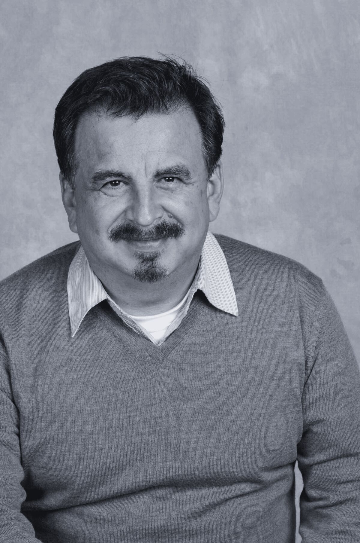 A man in a shirt and sweater