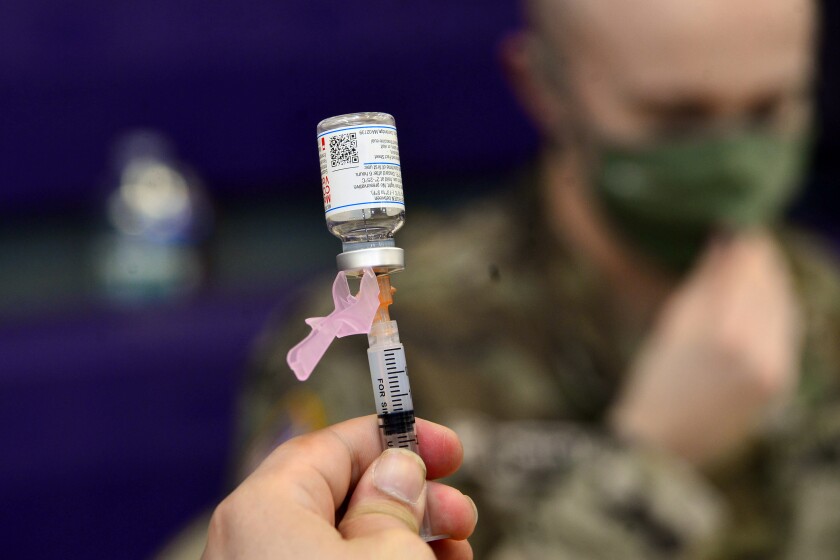 FILE - Spc. Brady McNeil, a radiologist with the Vermont Army National Guard, draws up a dose of the Moderna COVID-19 during a vaccination clinic at the Brattleboro Area Middle School, April 14, 2021, in Brattleboro, Vt. More than 11,000 members of the Air National Guard and Reserve did not meet the Thursday, Dec. 2, deadline to get the COVID-19 vaccine, and could begin to face consequences if they don't get the mandated shots or receive an exemption. (Kristopher Radder/The Brattleboro Reformer via AP, File)