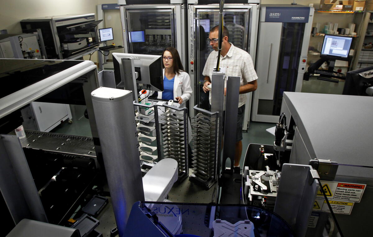Engineering lab manager Dan Scheibe (right) and staff researcher Jenna Woo (left) work in the lab at Takeda.