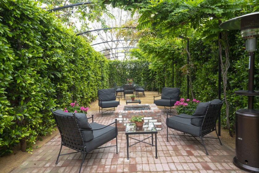 A garden with seating and walls of greenery offers a quiet oasis.