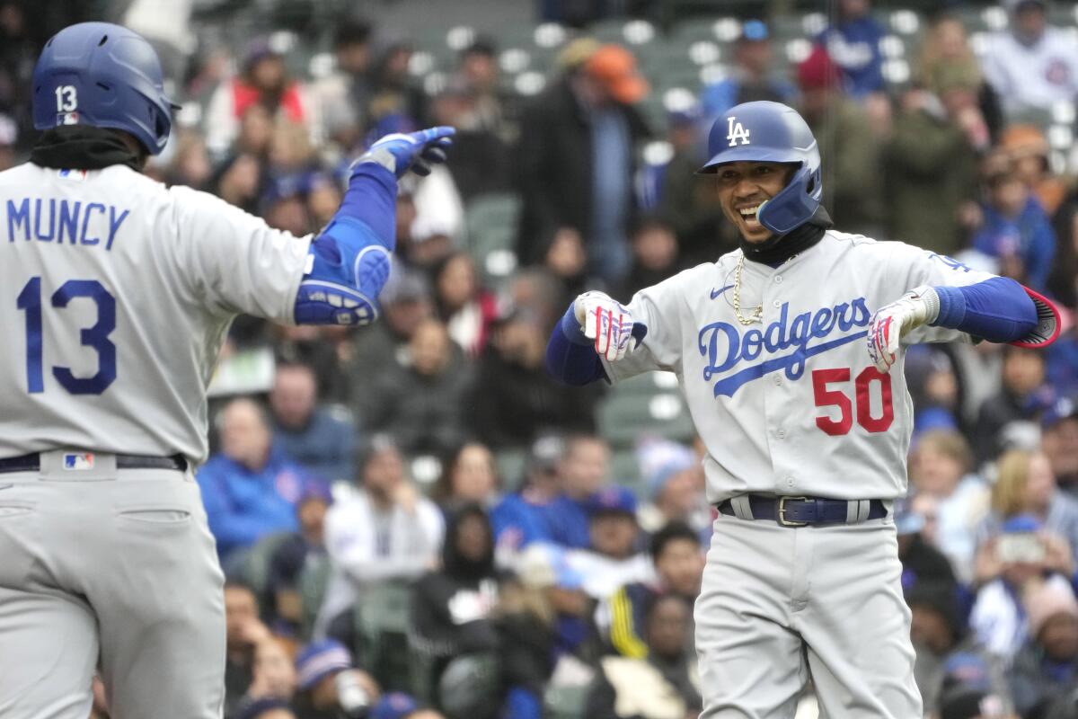 The Dodgers' Mookie Betts smiles as he celebrates with Max Muncy after hitting a two-run home run