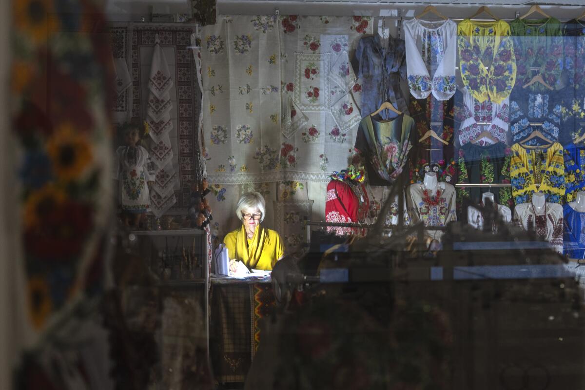 A seller shines a flashlight during a power outage in an underground shopping mall in central Kyiv, Ukraine.