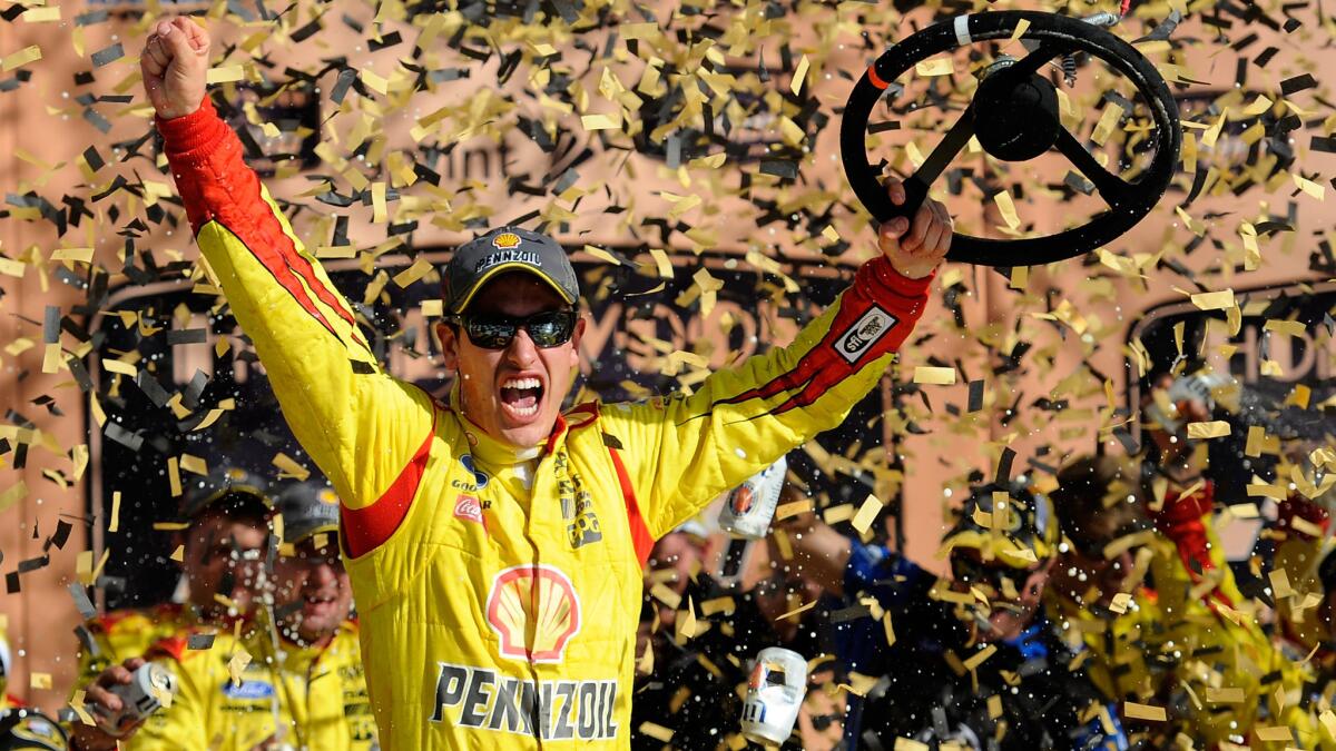 Joey Logano celebrates his NASCAR Sprint Cup victory at Kansas Speedway on Sunday.