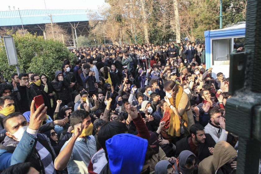 FILE - In this Saturday, Dec. 30, 2017 file photo taken by an individual not employed by the Associated Press and obtained by the AP outside Iran, university students attend a protest inside Tehran University while anti-riot Iranian police prevent them to join other protestors, in Tehran, Iran. As protests over Iran's faltering economy rapidly spread across the country, a channel on a mobile messaging app run by an exiled journalist helped fan the passions of some of those who took to the street. The Telegram app shut down a channel run by Roohallah Zam after Iranian authorities complained that it was inciting violence. (AP Photo, File)