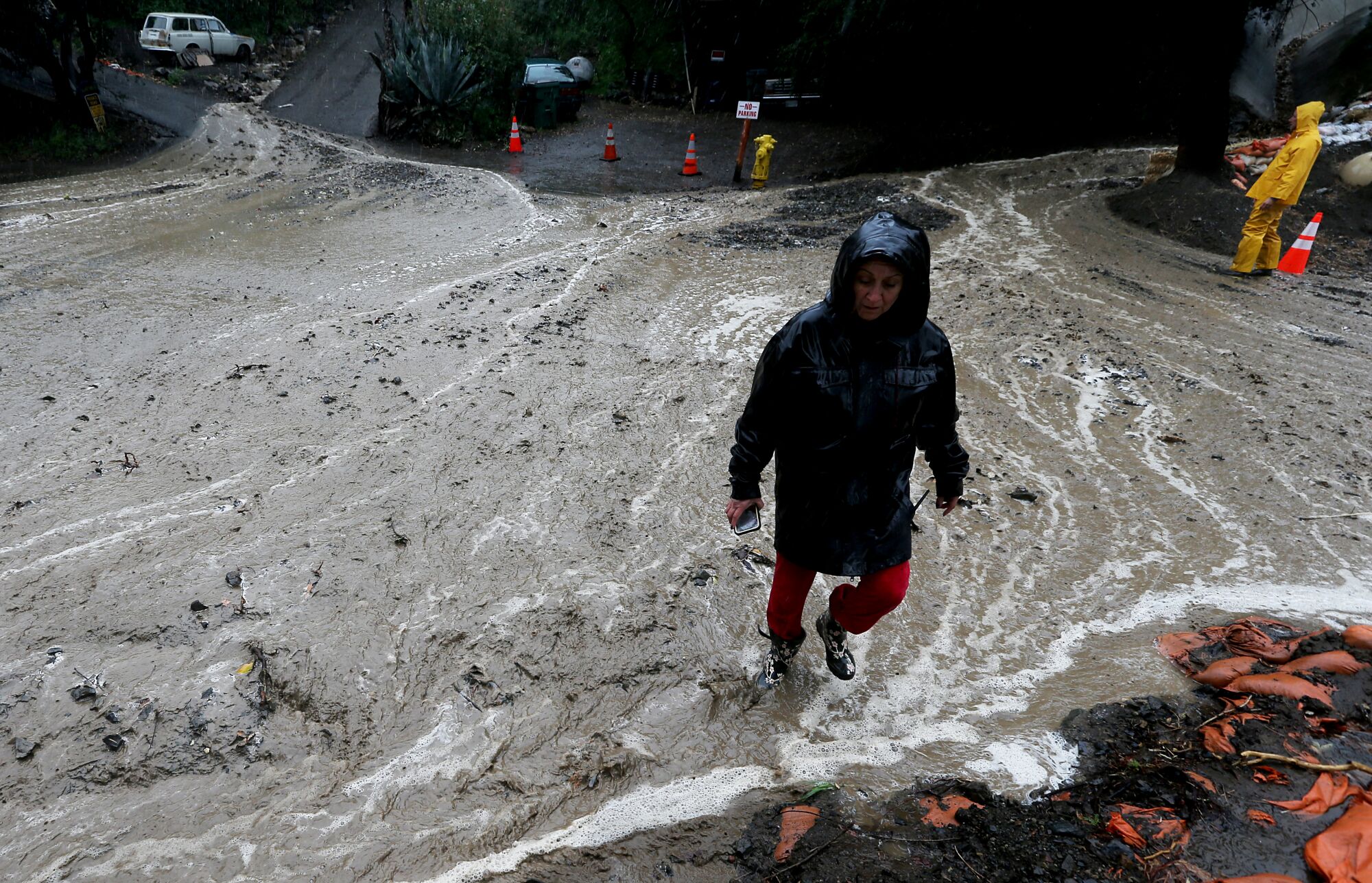 A woman standing in a flooded street.