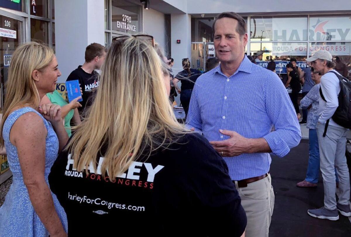 Democratic congressional candidate Harley Rouda talks with a volunteer outside his Costa Mesa campaign office. Rouda, a real estate executive, is trying to unseat 15-term Republican Rep. Dana Rohrabacher in the 48th District.