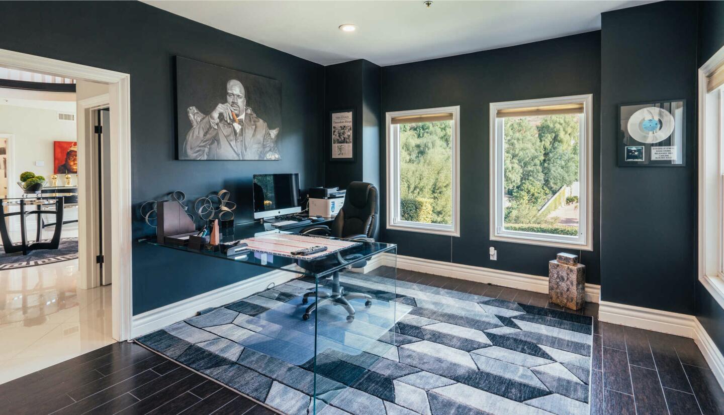 Tile floors, large windows and a portrait of Shaq with a cigar in an office off the foyer.