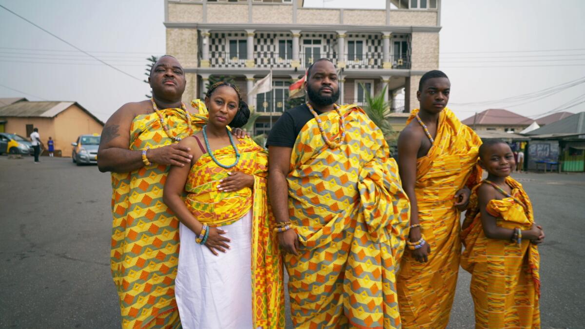 A family dressed in bright yellow African prints.