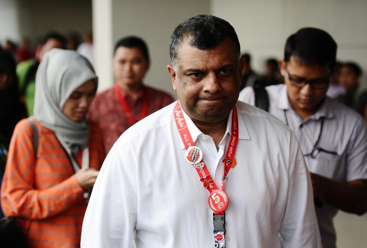 AirAsia Group chief executive Tony Fernandes, center, attends a news conference about the search for a missing jet at Juanda International Airport in Surabaya, Indonesia, on Dec. 29.