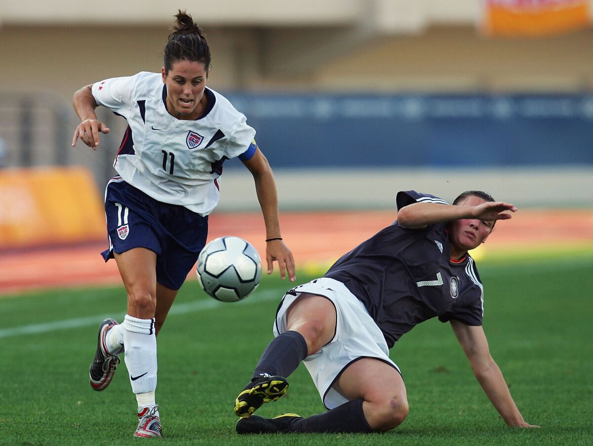 Julie Foudy, 2004 Olimpiyatları sırasında Alman Pia Wunderlich'i geçtikten sonra topu kontrol ediyor.
