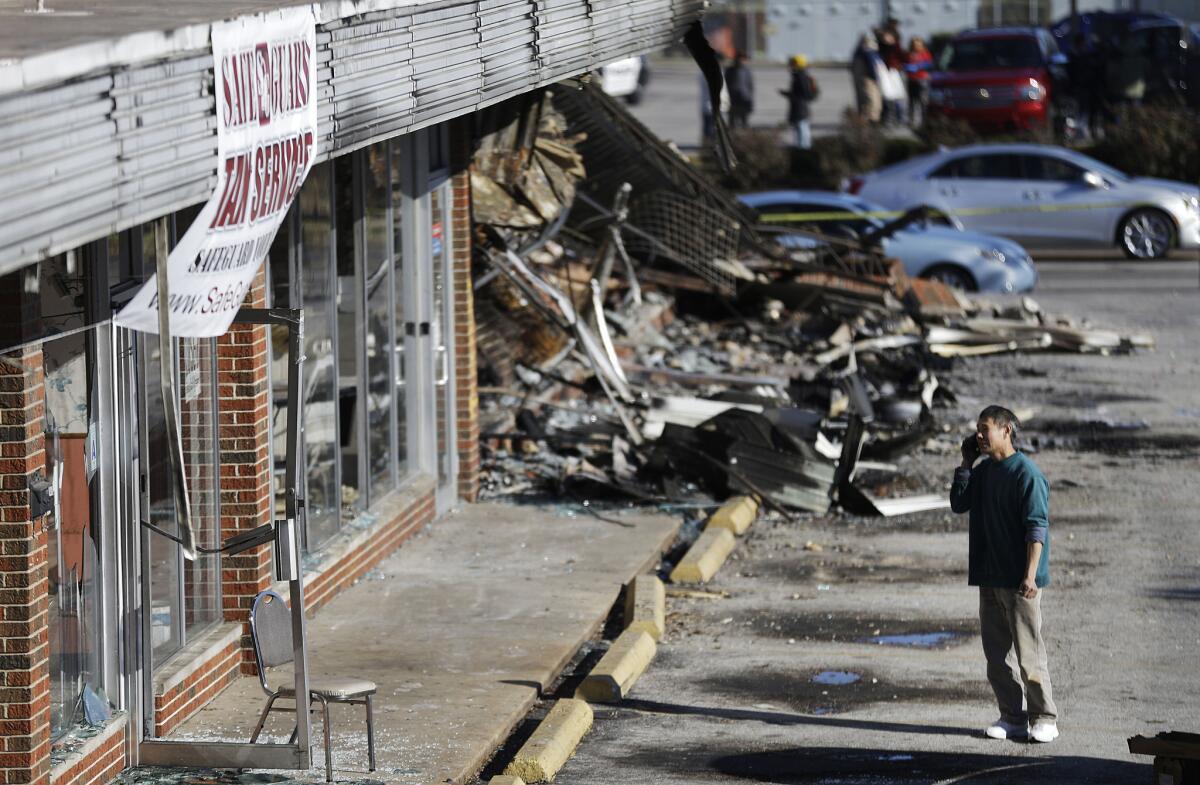 Shan Zhao, owner of On On Chop Suey restaurant in Ferguson, examines the damage to his business that occurred during unrest the previous night.