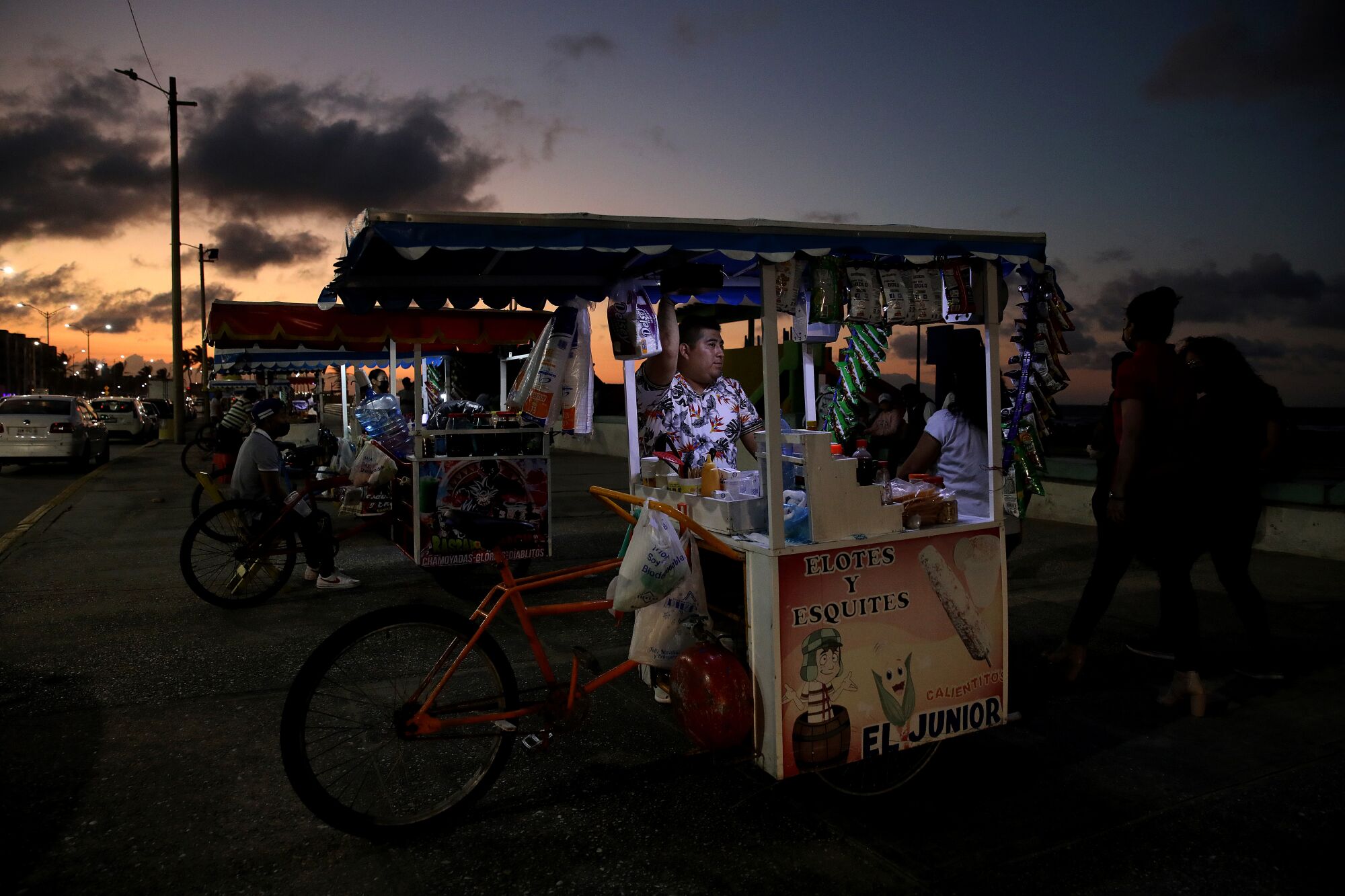 A man sells snacks near the waterfront.