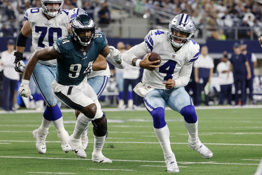 Philadelphia Eagles defensive end Josh Sweat (94) chases Dallas Cowboys quarterback Dak Prescott (4) out of the pocket in the second half of an NFL football game in Arlington, Texas, Monday, Sept. 27, 2021. (AP Photo/Michael Ainsworth)