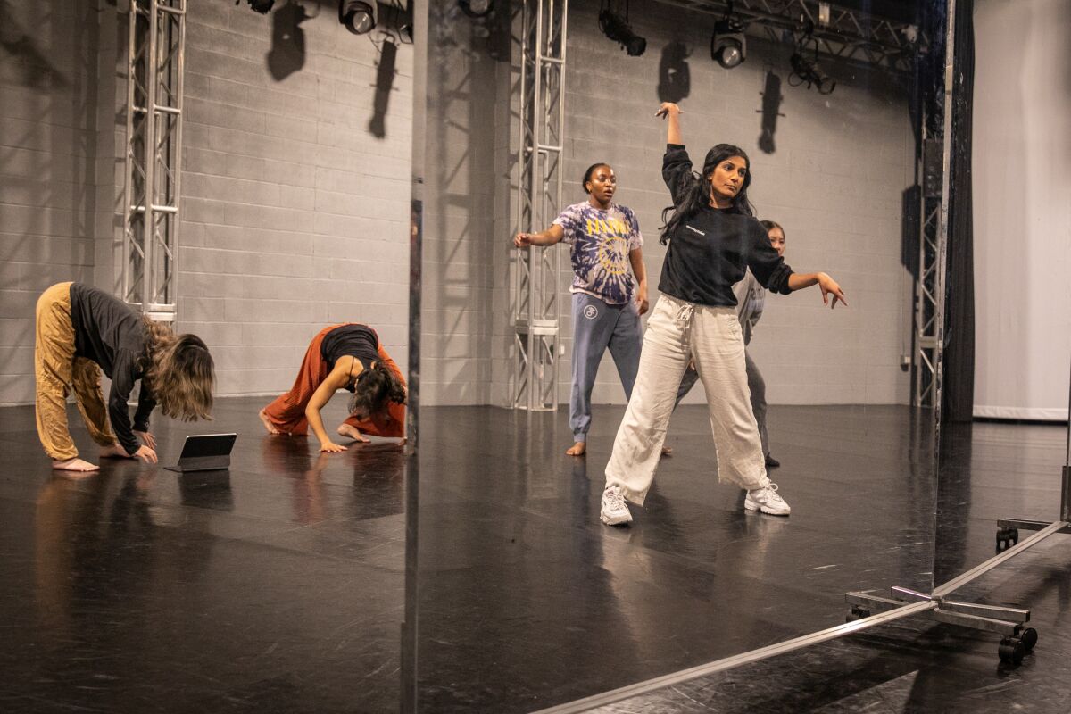 A choreographer leads rehearsals for dancers.  