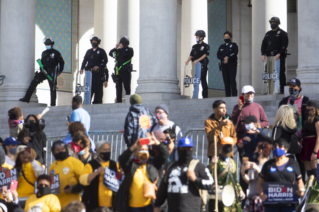 Police officers keep watch on a crowd outside Los Angeles City Hall.