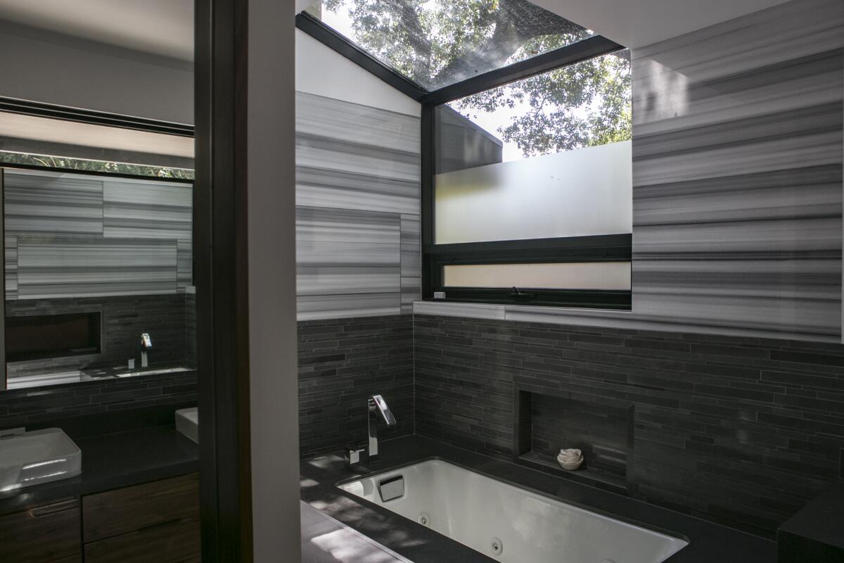 One of Sunnie Kim's favorite spots: her master bathroom tub, where a new skylight allows her to gaze at a giant oak while bathing.