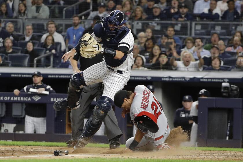 Los Angeles Angels' Michael Hermosillo (21) slides past New York Yankees catcher Kyle Higashioka to score on a throwing error by relief pitcher Adam Ottavino during the sixth inning of a baseball game Wednesday, Sept. 18, 2019, in New York. (AP Photo/Frank Franklin II)