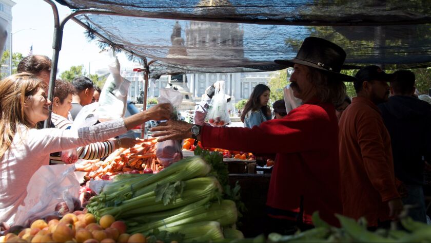 Customers shop at San Francisco's Heart of the City Farmers Market in 2014. The market made a successful push to let local residents know their federal food assistance was welcome, taking in $230,000 in electronic benefits the previous year.