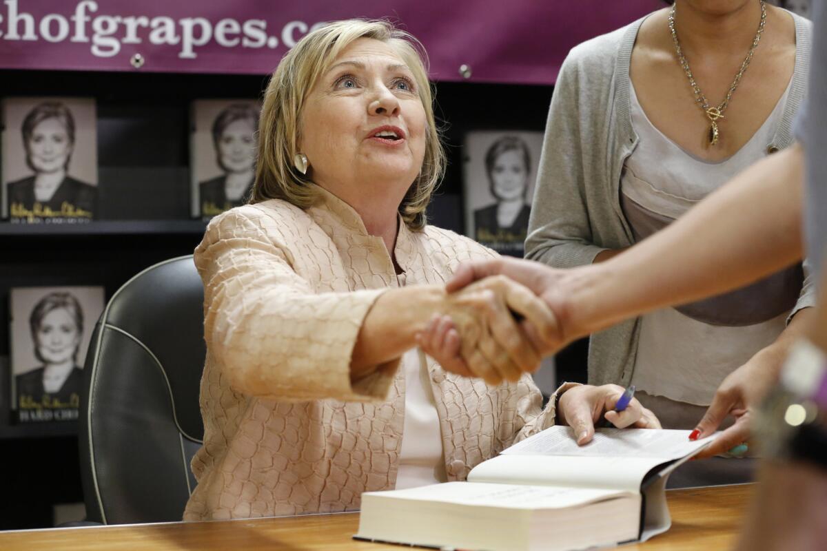 Former Secretary of State Hillary Rodham Clinton speaks with customers at a signing party for her book "Hard Choices" at a Martha's Vineyard bookstore on Wednesday. She later attended a party with President Obama.