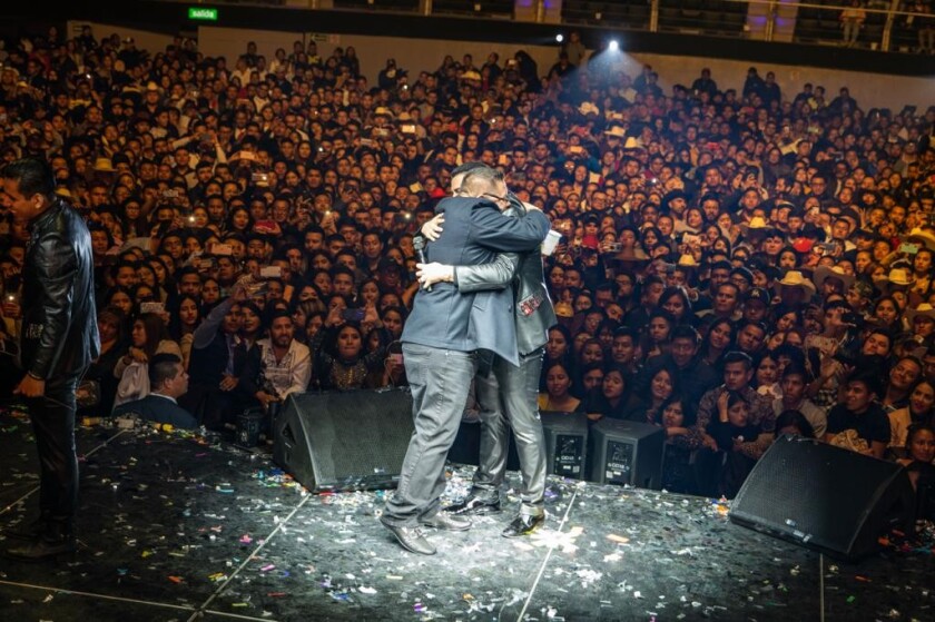Artista y manager, Eduin Caz e Isael Gutiérrez, se fusionan en un abrazo que sella una colaboración de éxito.