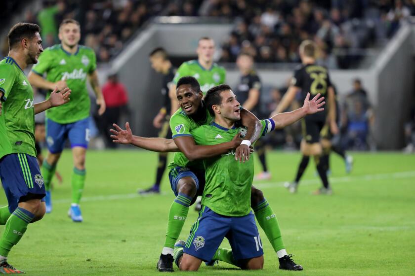 LOS ANGELES, CALIF. -- TUESDAY, OCTOBER 29, 2019: Los Angeles Football Club playing Seattle Sounders Football Club’s Joevin Jones, left center, celebrates Nicolás Lodeiro’s first half goal in playoffs at Banc of California in Los Angeles, Calif., on Oct. 29, 2019. (Allen J. Schaben / Los Angeles Times)