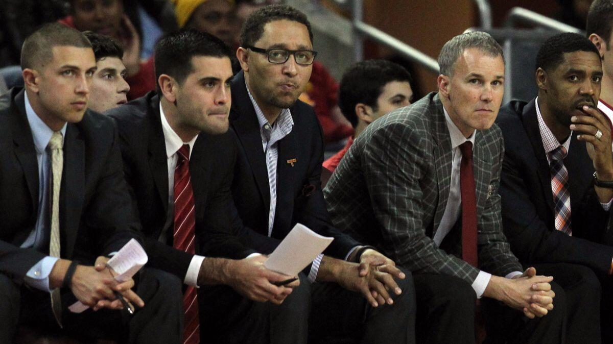 USC assistant men's basketball coach Tony Bland, center with glasses, next to USC head coach Andy Enfield, right, and other members of the USC coaching staff in a game against Vermont in December 2014.