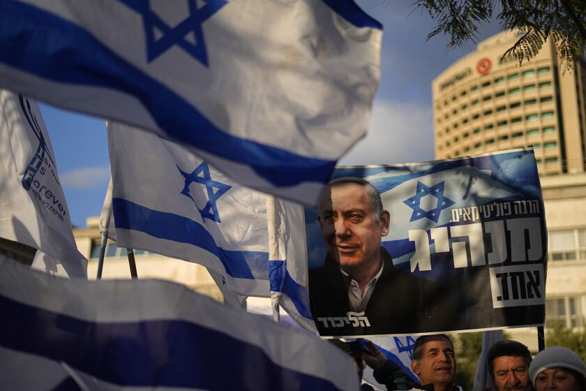 Right-wing Israelis rally in support of Prime Minister Benjamin Netanyahu, seen in poster, and his government's plans to overhaul the judicial system, in Tel Aviv, Israel, Thursday, March 30, 2023. (AP Photo/Ariel Schalit)