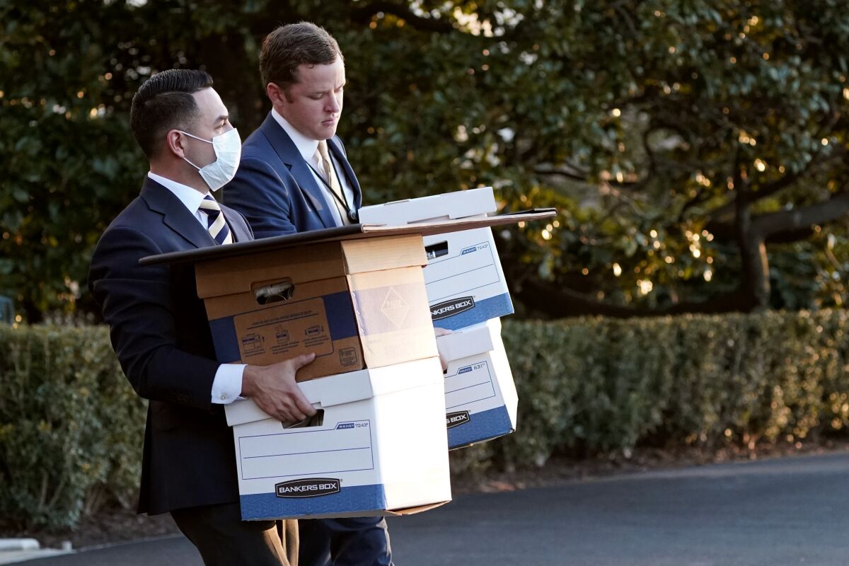 Trump White House staff members carry boxes 