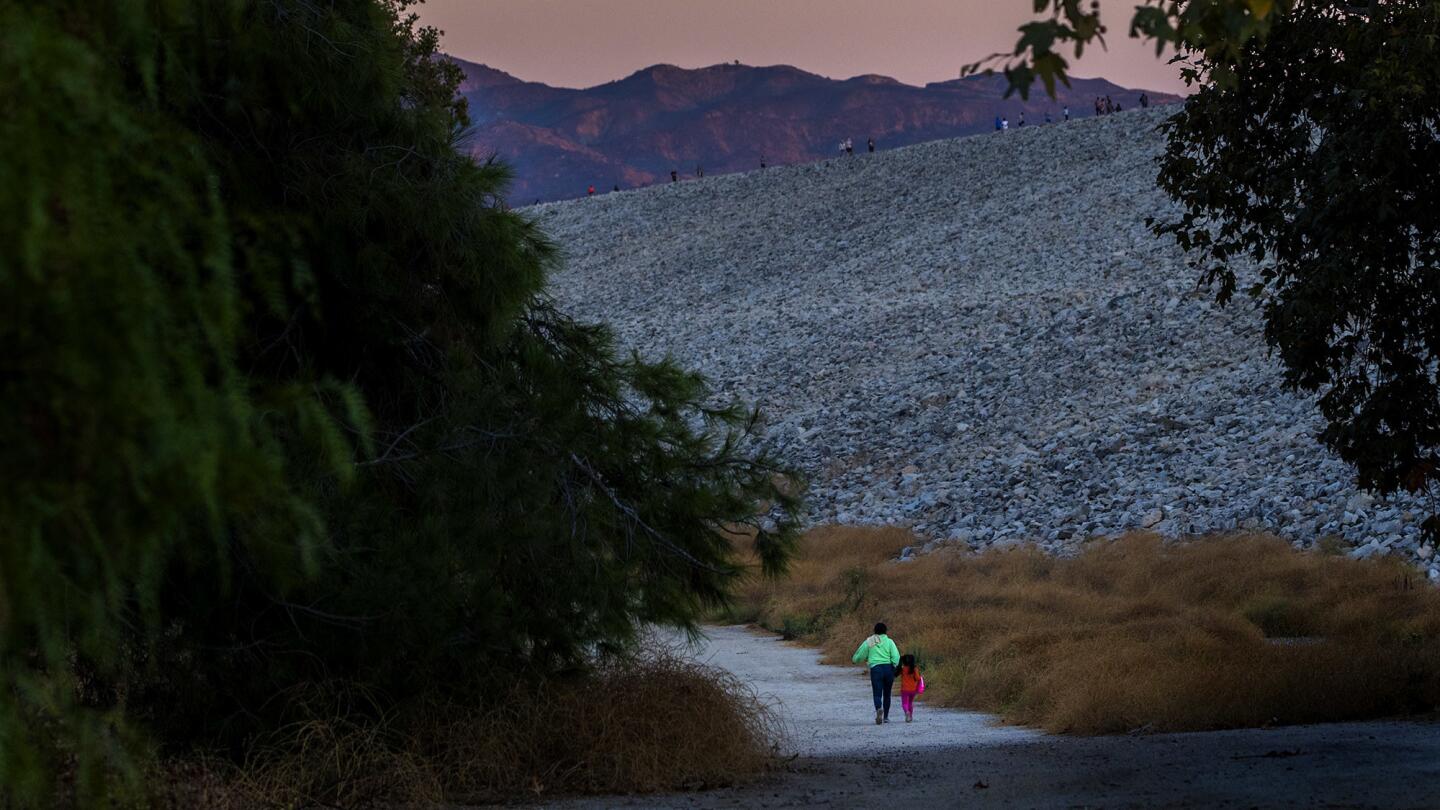 Pedestrians use one of the circular paths below the dam.