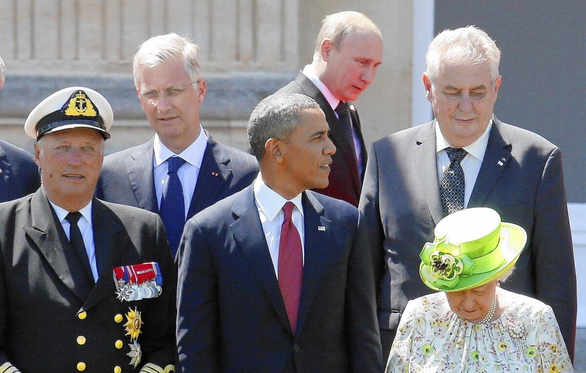Russian President Vladimir Putin, center, passes behind President Obama, Britain's Queen Elizabeth II and other dignitaries before a group photo in Normandy, France, during events to mark D-day.