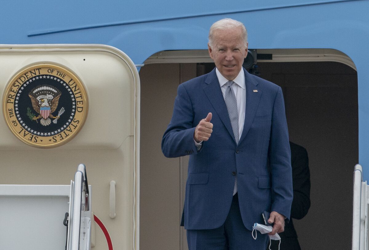 President Biden gestures as he boards Air Force One.