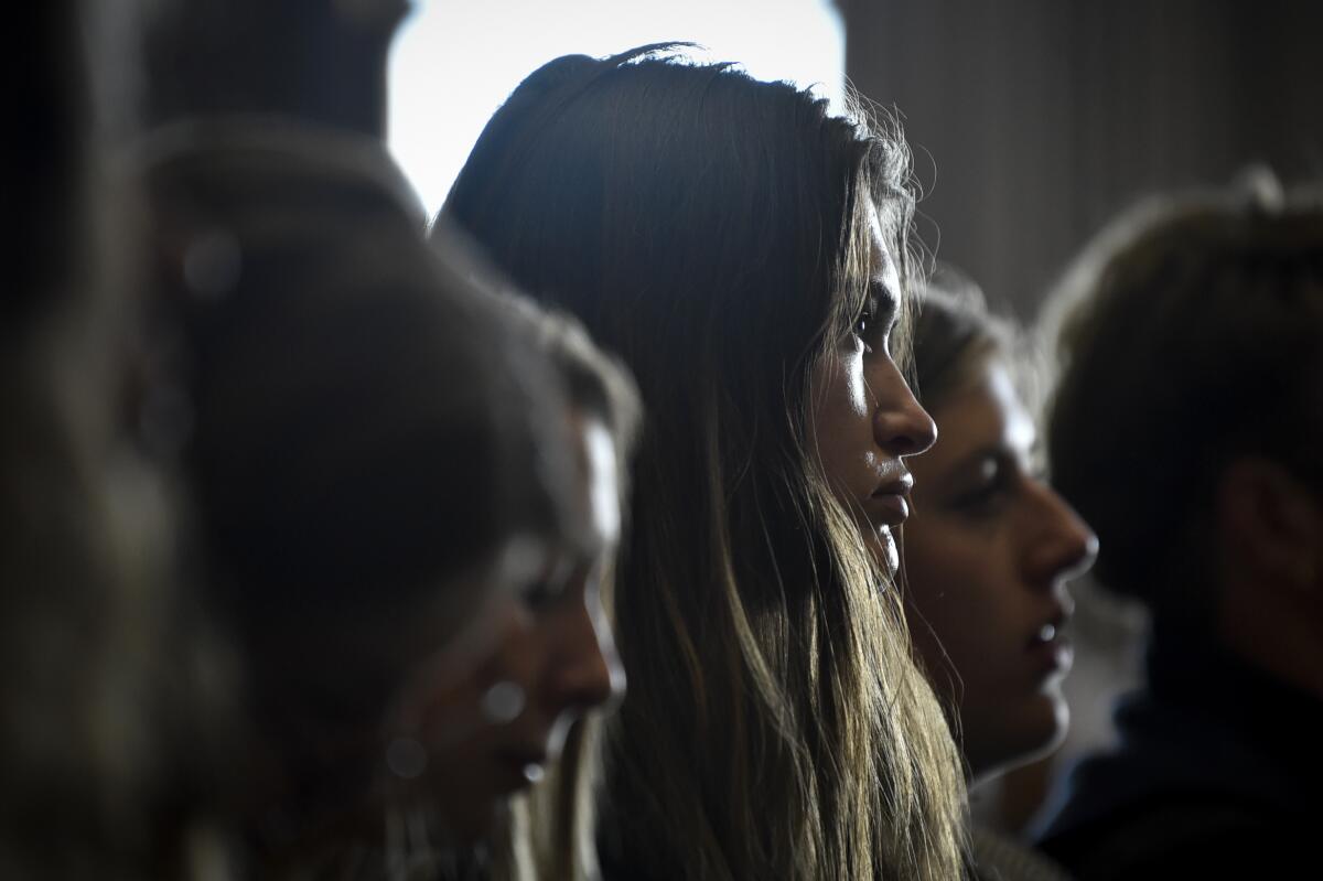 A woman listens to testimony during a hearing.
