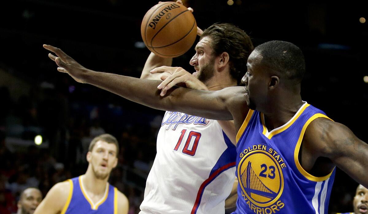 Seven-foot-one Spencer Hawes (10), pulling down a rebound against Warriors power forward Draymond Green, gives the Clippers a backup big man to DeAndre Jordan and Blake Griffin who can stretch the floor with his three-point shooting.