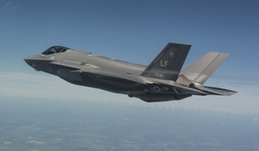 A Lockheed Martin F-35 Lightning II, with components built in Huntington Beach, flies overhead.