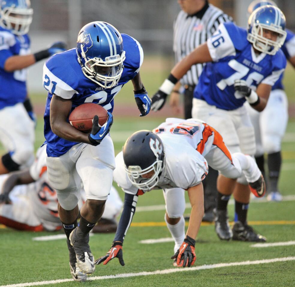 Burbank's James Williams evades a Chatsworth defender and makes the first touchdown at the new Memorial Field on Thursday, August 23, 2012.